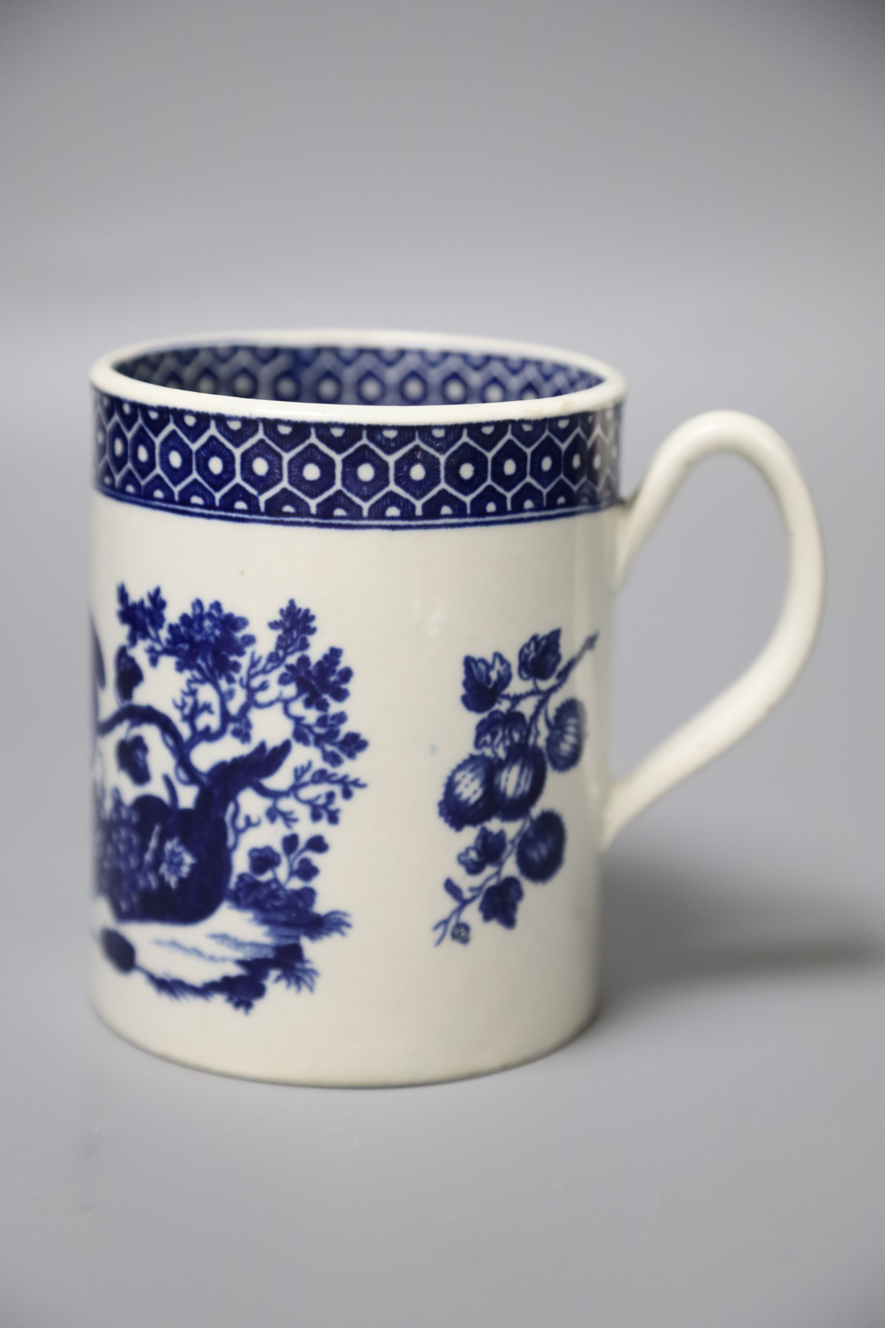 An 18th century Worcester mug printed after Hancock with Parrot Pecking Fruit pattern very rare inside and outside cell border patterns